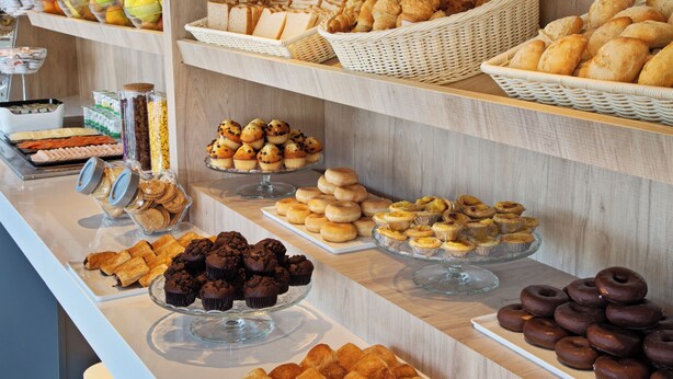 Un bufé con diversos productos de panadería y pastelería.