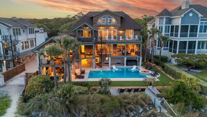 A large, multi-story house with a swimming pool, outdoor seating, and a well-maintained garden. - 95 Dune Lane -Oceanfront | Island Oasis | Booking now for 2027! (Hilton Head Island)