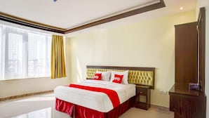 A hotel room with a large bed, a nightstand, a wardrobe, and a window with curtains. - Al Tamayoz Al Raqi Al Salamah (Jeddah)