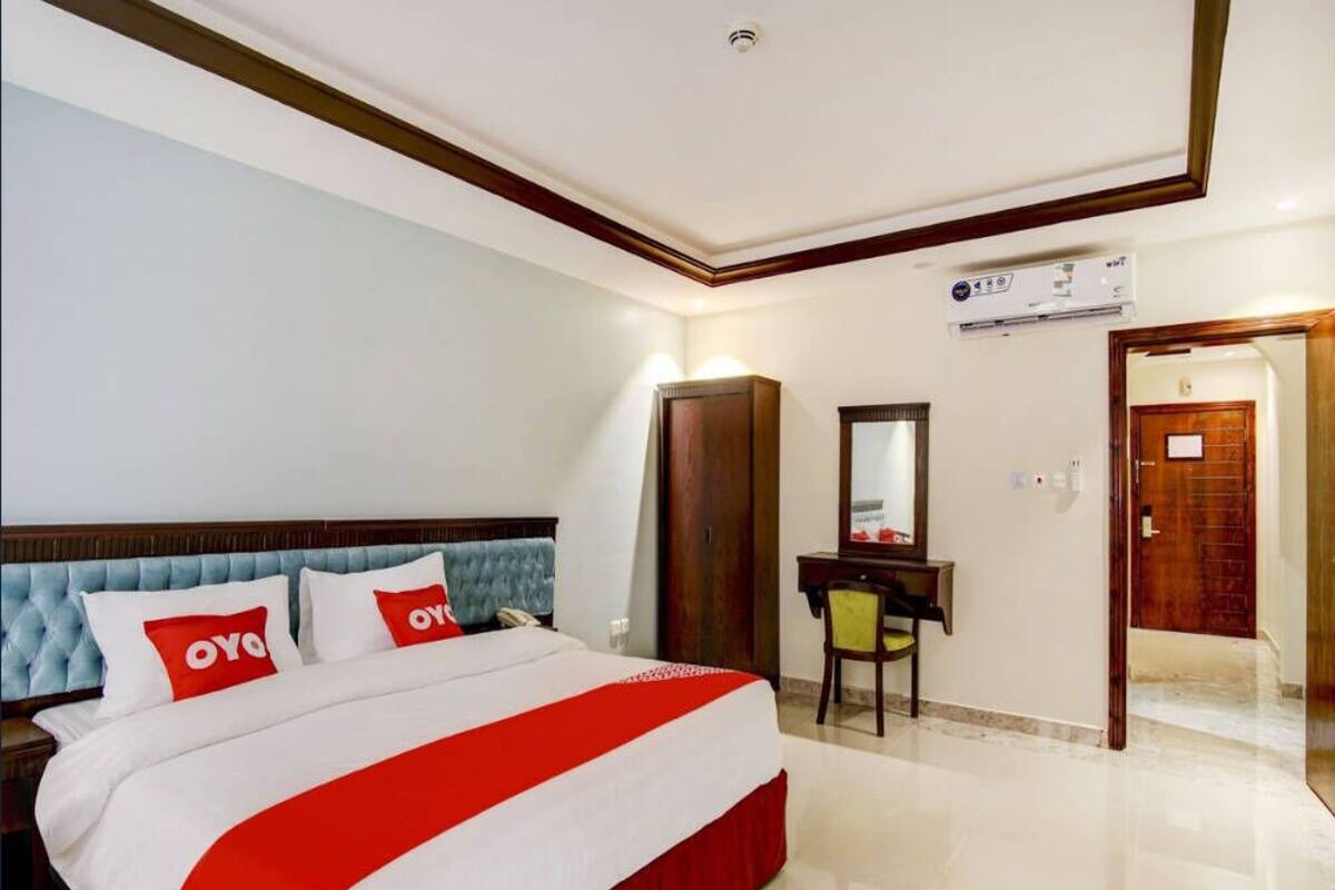 Une chambre d’hôtel équipée d’un lit, d’un bureau, d’une chaise, d’un miroir et d’un appareil de climatisation.