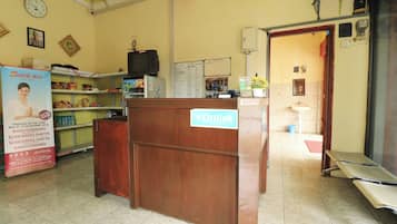 A reception desk with a sign, a clock, and a counter with various items.