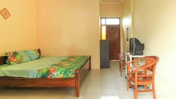 Quarto com cama, escrivaninha com cadeira, ar condicionado e porta para outro cômodo.