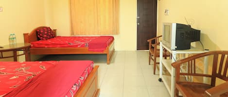 A hotel room with two beds, a television on a stand, a chair, and a door.