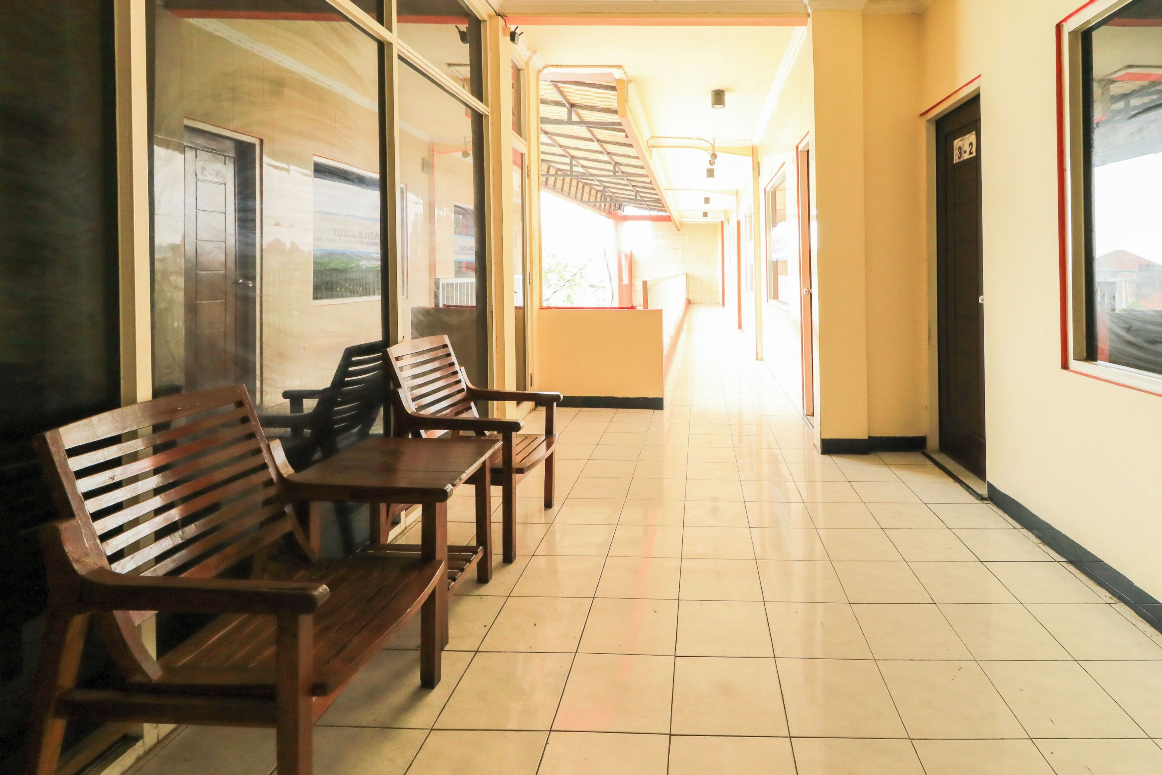 A hallway with wooden benches and a tiled floor.