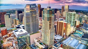 Paisagem urbana com vários edifícios altos, incluindo um edifício Optiv de destaque.