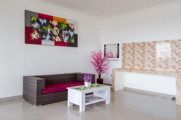 Un salon moderne avec un canapé, une table basse et une plante décorative.