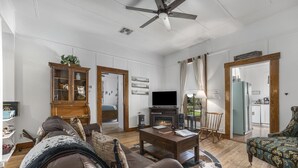 A living room with a fireplace, leather sofa, wooden coffee table, and a television.