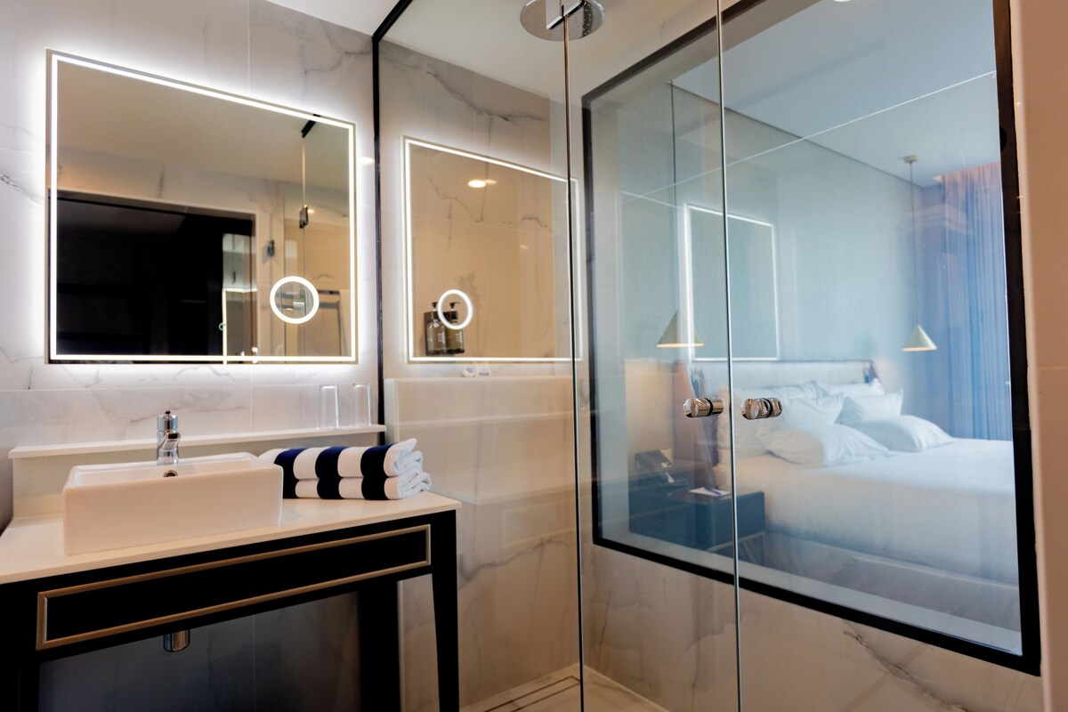 Une salle de bain moderne avec une douche à parois de verre, un meuble-lavabo et un grand miroir.