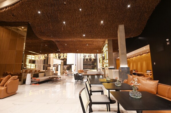 A spacious lobby with a high ceiling, modern furniture, and a central seating area.
