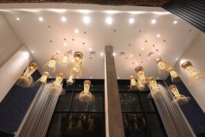 A modern interior with multiple hanging light fixtures and a large central pillar.