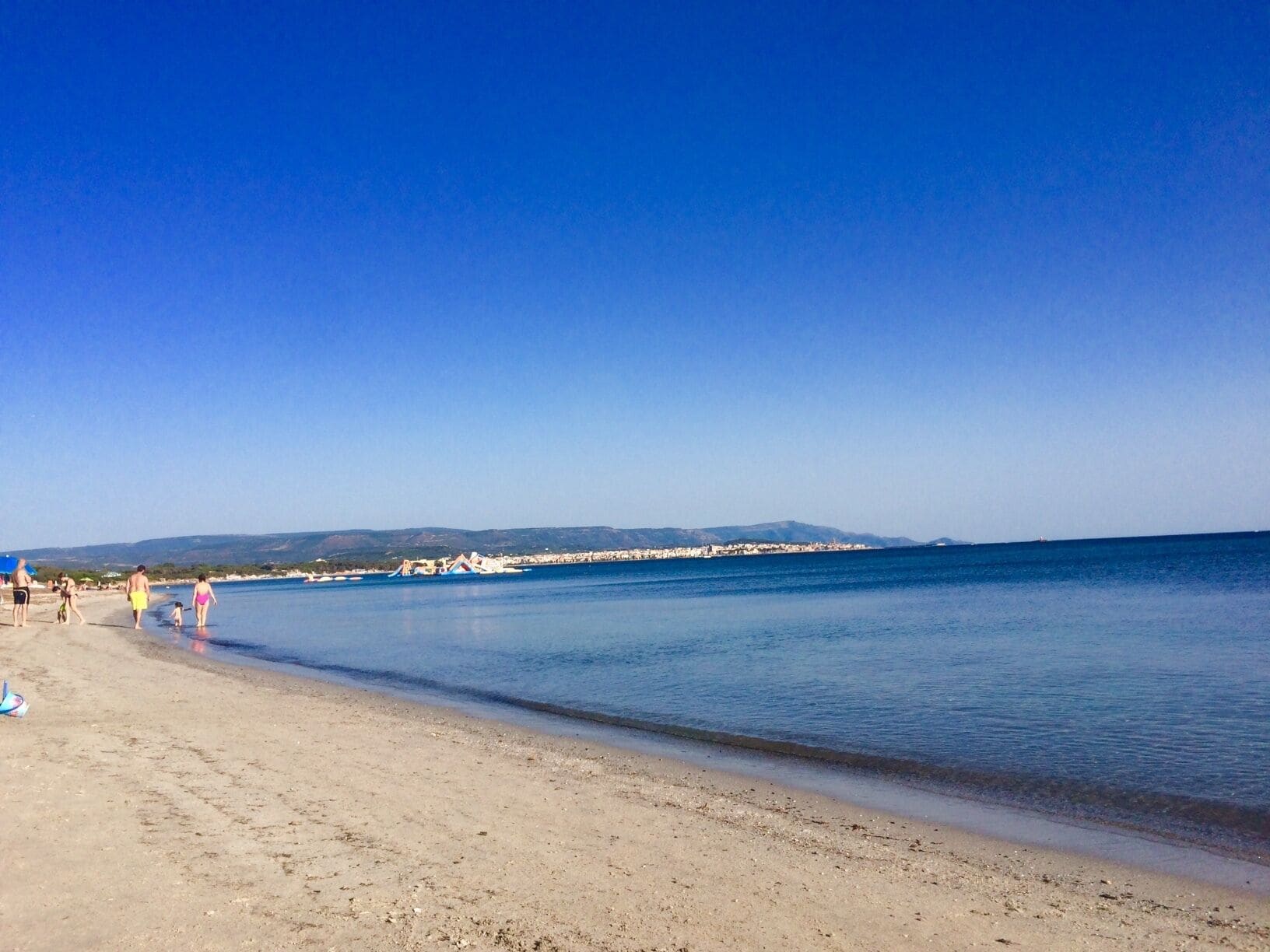 Uma praia com céu claro e mar calmo.