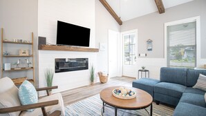 Una sala de estar con chimenea, televisor, sofá y mesa de centro.