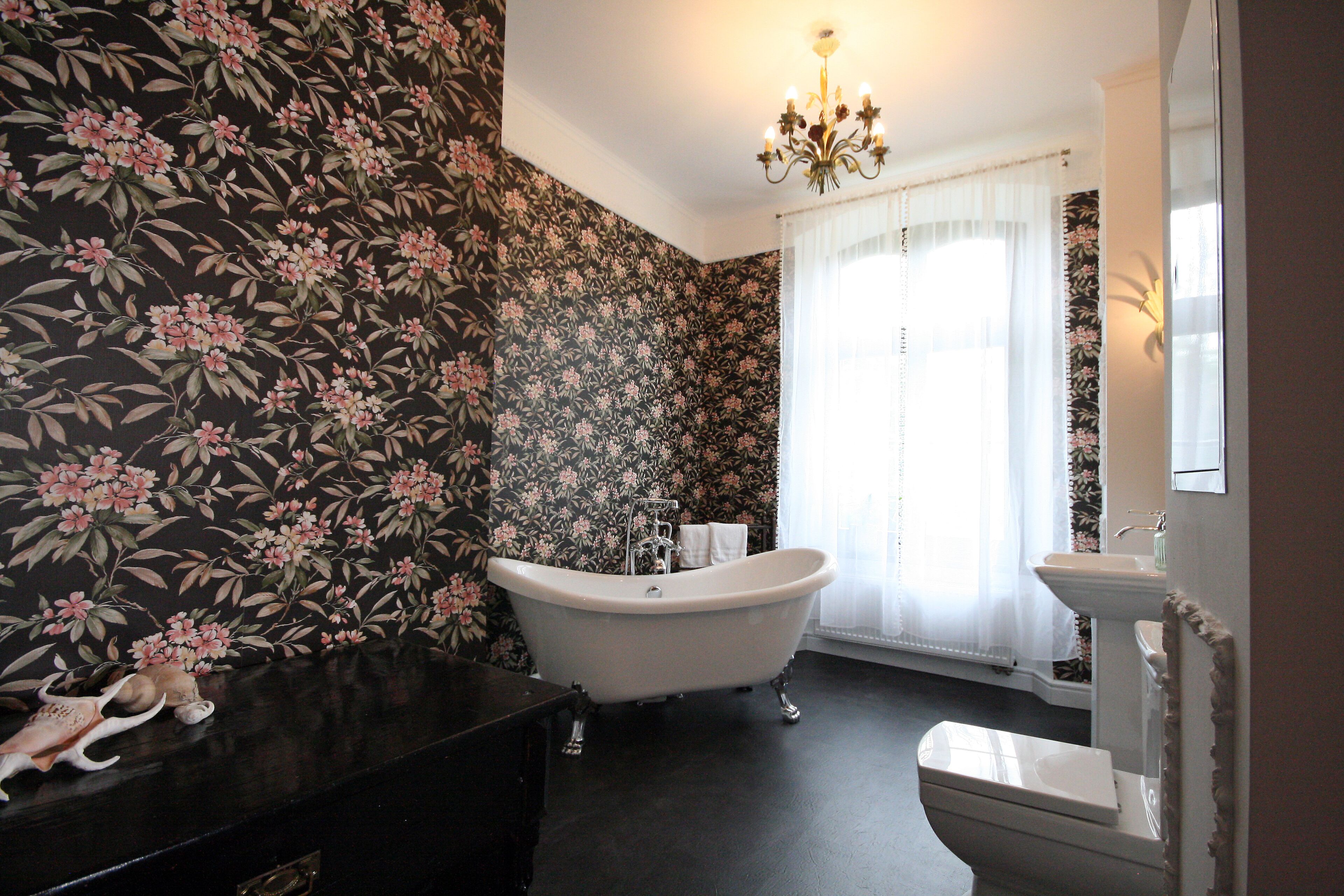 A bathroom with a freestanding bathtub, a sink, and a mirror.