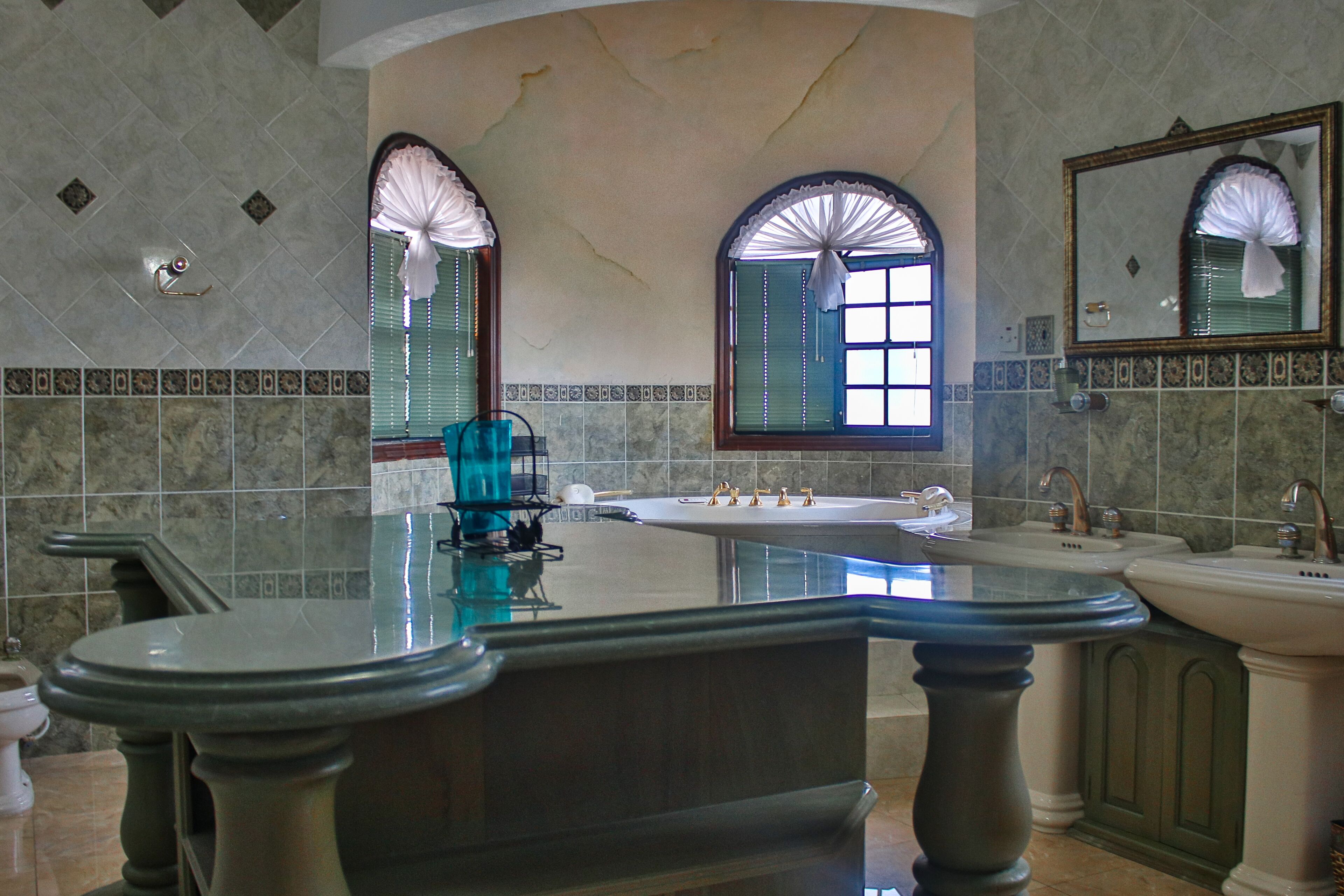 A bathroom with a large bathtub, two sinks, and a vanity with a mirror.