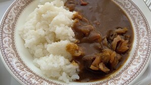 A plate of white rice and a brown sauce with chunks of meat. - Smile Hotel Nabari (Nabari)
