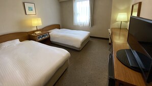 A hotel room with two beds, a desk with a computer, a TV, a lamp, and a window with curtains. - Smile Hotel Nabari (Nabari)