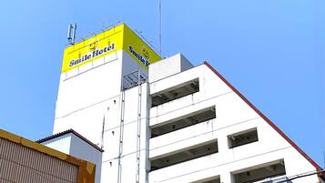 A building with a yellow sign reading "Smile Hotel" and a smiley face logo.