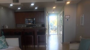 Amplia sala de estar con kitchenette, una mesa de comedor y un sofá.