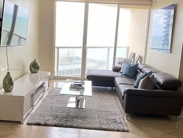 A modern living room with a sofa, a coffee table, and a TV.
