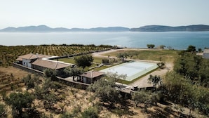 Een villa met een tennisbaan, een zwembad en uitzicht op zee.