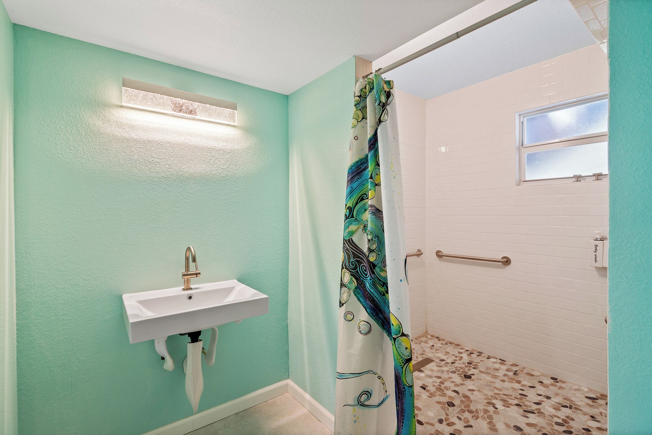Ein Badezimmer mit Waschbecken, Duschvorhang und Fenster.