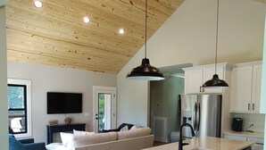 Een ruime keuken met een groot schiereiland, houten plafond en moderne apparatuur.