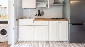 A compact kitchen with white cabinetry, a stainless steel refrigerator, and a microwave. - Vacation home Jorge by Interhome (El Rosario)