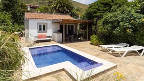 A small house with a tiled roof, a swimming pool, and a patio area with lounge chairs. - Vacation home Jorge by Interhome (El Rosario)
