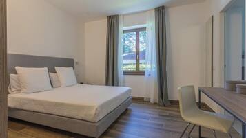 Una camera da letto con un letto, una scrivania e una sedia.