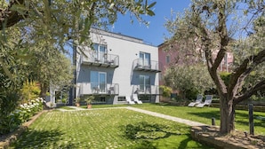 Un bâtiment moderne doté de balcons, d’une pelouse bien entretenue et d’un espace extérieur aménagé pour s’asseoir.