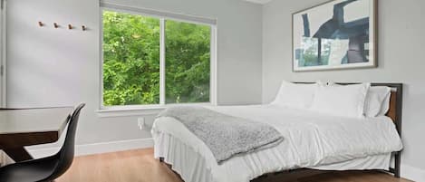 A bedroom with a bed, a desk, and a chair.