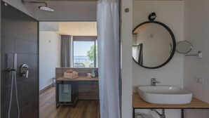 Un baño moderno con un espejo grande, un lavabo y una ducha.