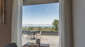 A dining area with a view of the sea and a balcony with outdoor seating.