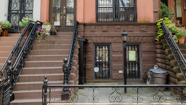 A row of three-story townhouses with a central staircase, black iron railings, and a small outdoor seating area. - 1899 Historic Luxury Brooklyn Brownstone (Brooklyn)