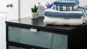 A bathroom with a black vanity, a framed mirror, a decorative wall piece, and a framed wall hanging. - The Ol' Cottage @ Davidson  (Davidson)