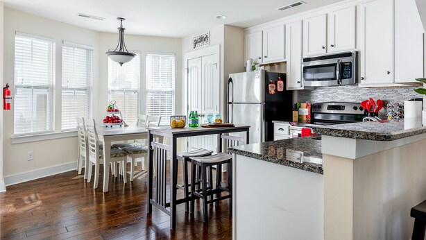 A modern kitchen with white cabinets, a granite countertop, and stainless steel appliances. - The Ol' Cottage @ Davidson  (Davidson)