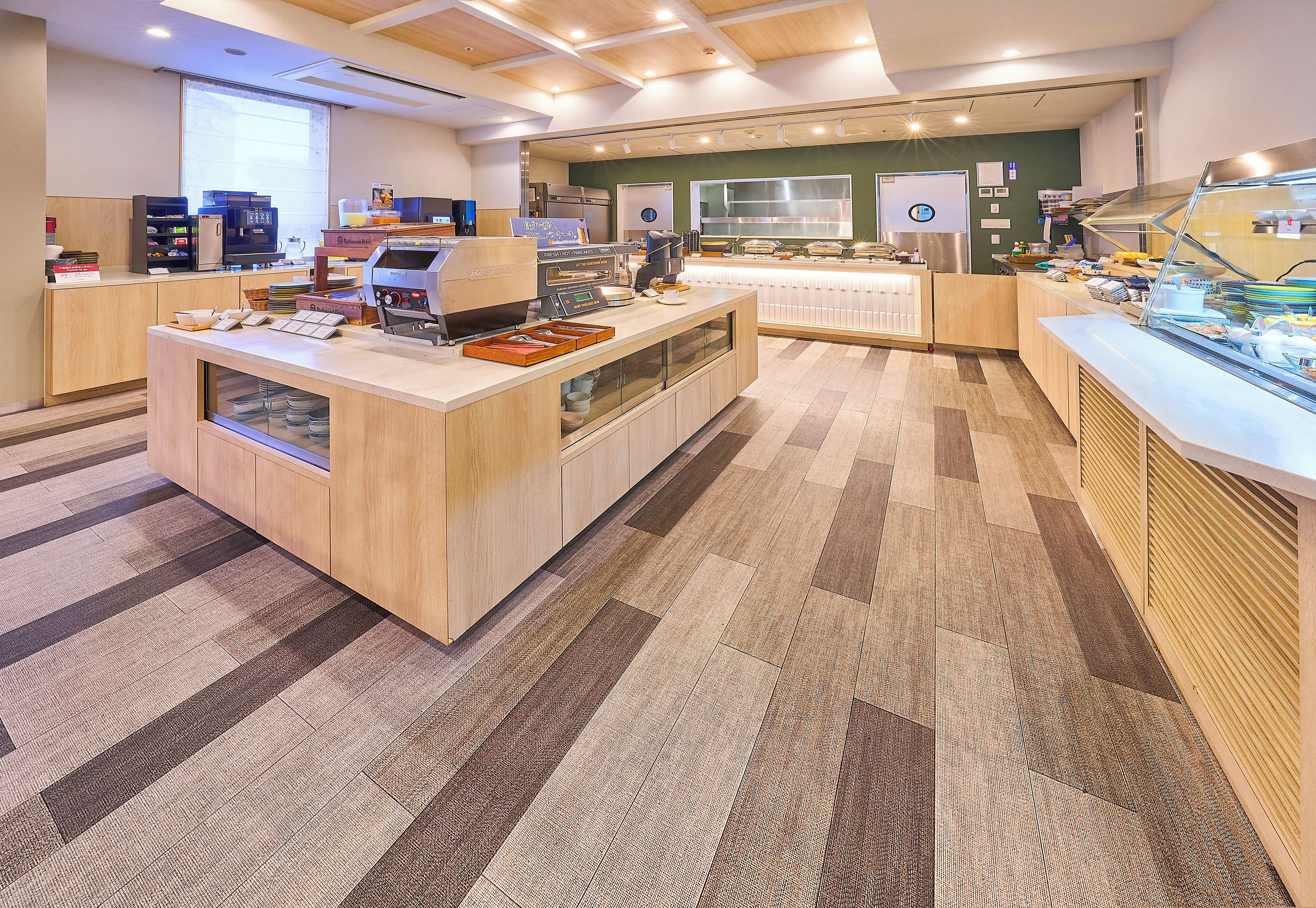 Un espace cuisine moderne comprenant un coin café, un réfrigérateur et un comptoir de buffet.