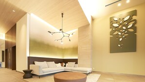 A modern lobby with a sectional sofa, a round coffee table, and a unique wall art piece. - Keisei Richmond Hotel Tokyo Kinshicho (Tokyo)