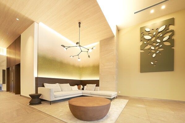 A modern lobby with a sectional sofa, a round coffee table, and a unique wall art piece. - Keisei Richmond Hotel Tokyo Kinshicho (Tokyo)