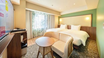 A hotel room with a bed, a desk, a chair, and a television.