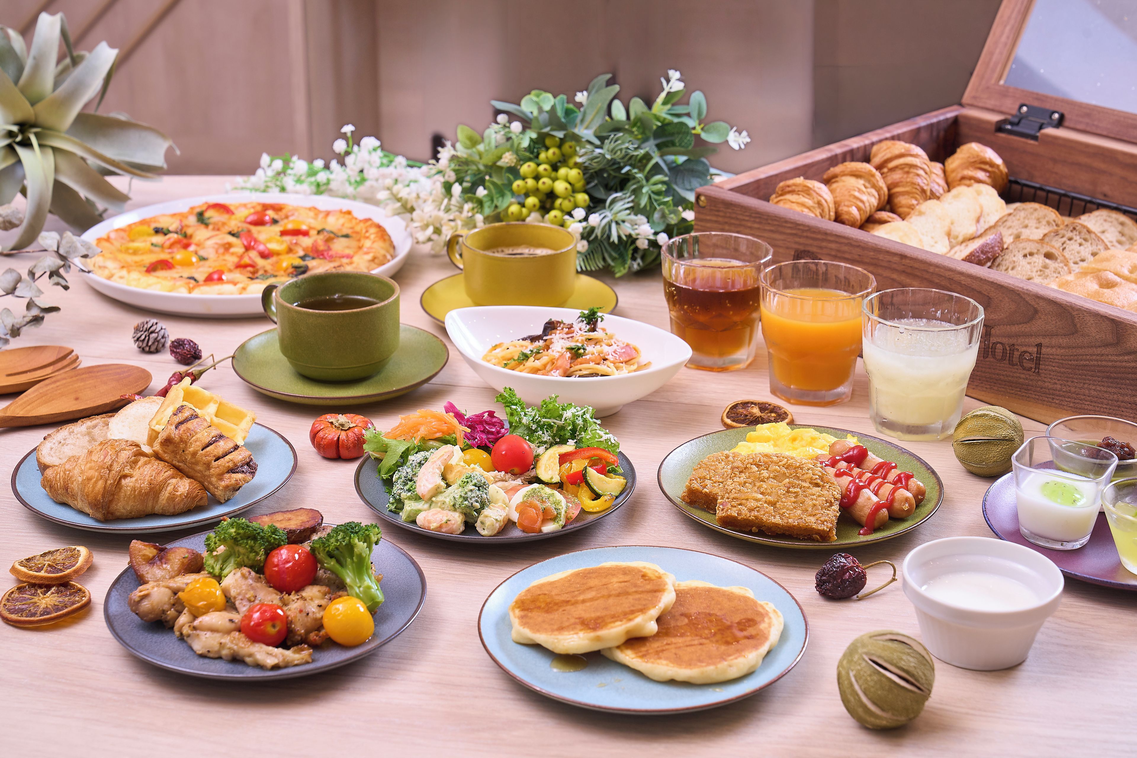 Un buffet de petit-déjeuner proposant une variété de plats, notamment des viennoiseries, des salades et des boissons.
