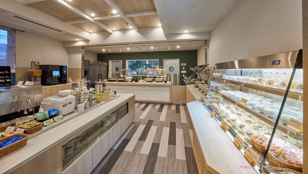 A modern kitchen with a central island, a refrigerator, and a display case with food items. - Keisei Richmond Hotel Tokyo Kinshicho (Tokyo)