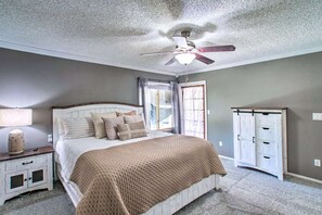 A bedroom with a bed, nightstand, dresser, and ceiling fan.