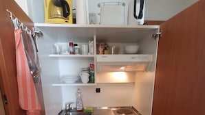 Een praktische keuken met een ingebouwde oven, een spoelbak en een magnetron.