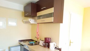 Een kleine keuken met een koelkast, een gootsteen, een koffiezetapparaat en een broodrooster.