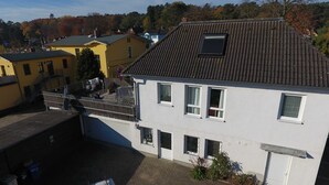 Een gebouw met twee verdiepingen, een pannendak en meerdere ramen.