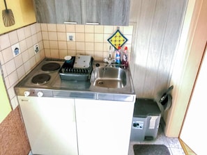 A compact kitchen with a stove, sink, and a small countertop.