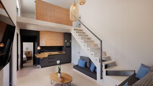 A modern interior with a staircase, a kitchen, and a seating area. - Greenstone Villas (Corfu)