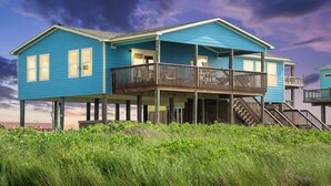 A two-story house with a balcony and a staircase leading to an upper level. - Beachfront | Expansive Deck, Grill & Ocean Views (Gilchrist)