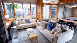 A modern living room with a sofa, coffee table, and dining area.